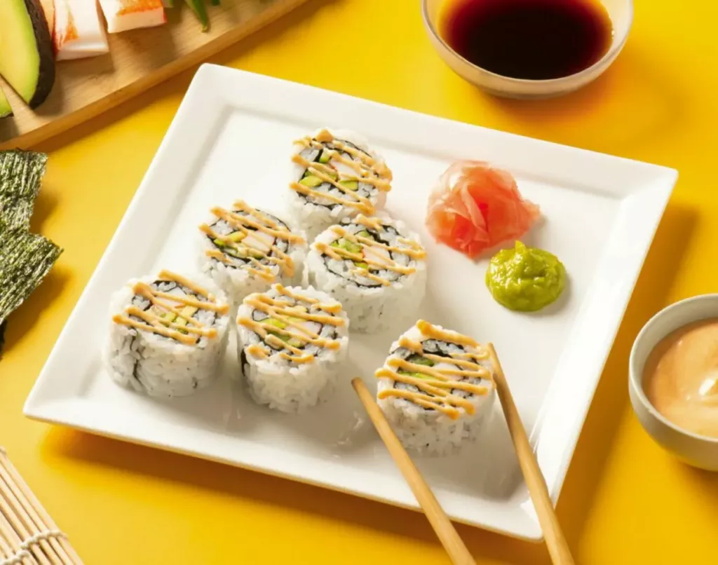 california roll on a white square plate on a yellow table