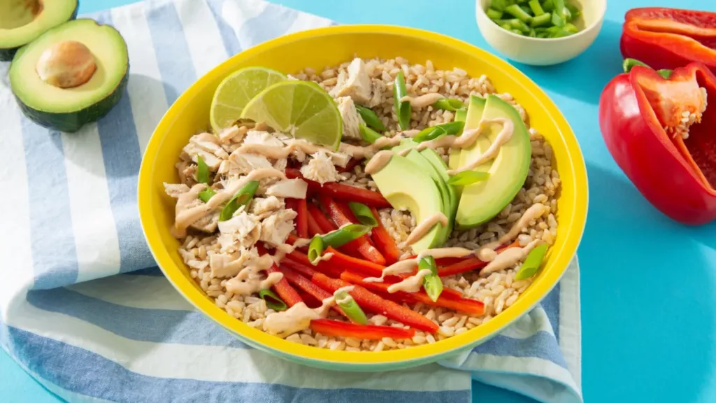 Spicy chipotle tuna bowl in a yellow bowl on a sky blue background