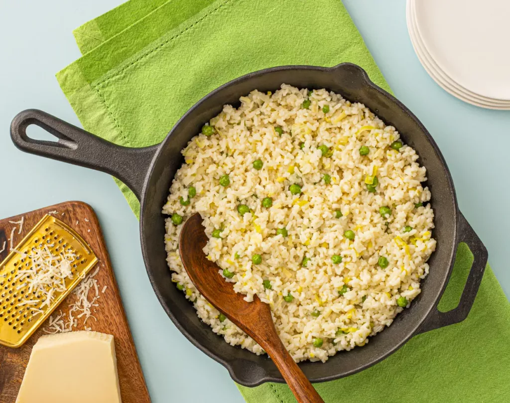 spring green risotto in a cast iron pan on a green napkin